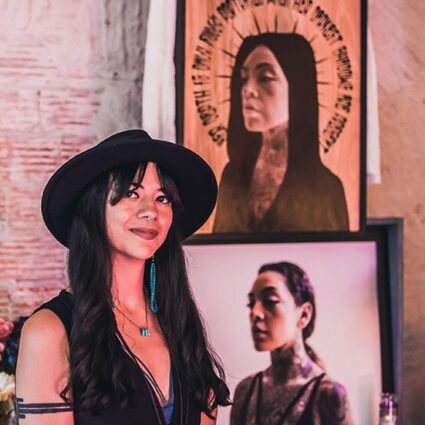 Albuquerque artist Jodie Herrera in front of artwork.