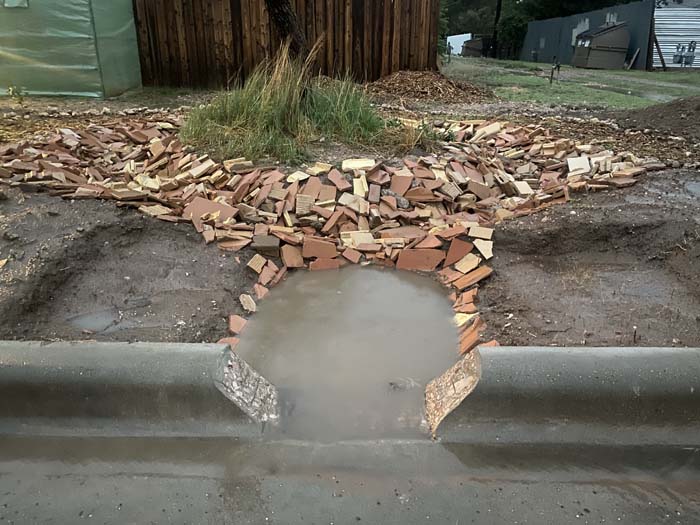 The first permitted residential curb cut in Lubbock. Rainwater moves from the street into an infiltration basin lined with building debris. The basin irrigates a mesquite tree and wild grass transplanted from a ranch in Tahoka, TX. 