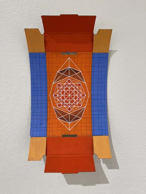 Geometric painting utilizing a penbox in hues of orange, red, and blue.