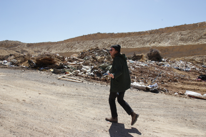 Brendan Sullivan Shea, a recent Moab Arts Reuse Residency artist, picks through trash at Moab's landfill.