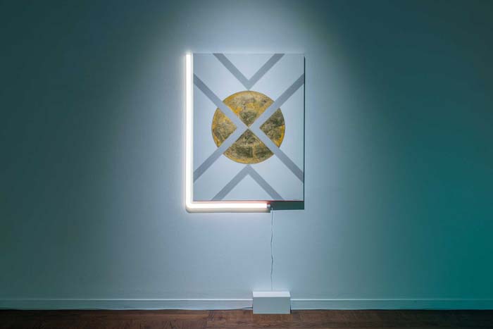 Painting of a gold orb with silver lines intersecting over it, and two bars of white neon on the left and bottom of the painting.