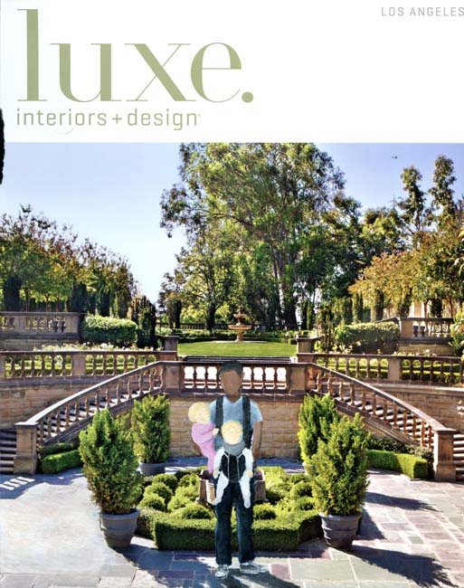 An image of a dark-skinned adult holding a blond toddler inserted onto the cover of an interior design magazine featuring the garden of an affluent home.