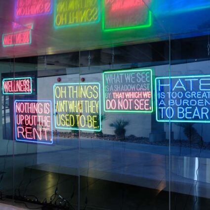 Window with various neon signs with text art