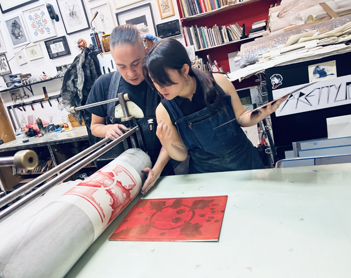 Ernesto Alva and Alondra Benitez discuss another artist's print at La Trampa Gráfica