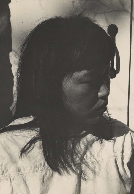 Black and white portrait of a young Ruth Asawa looking to the left.