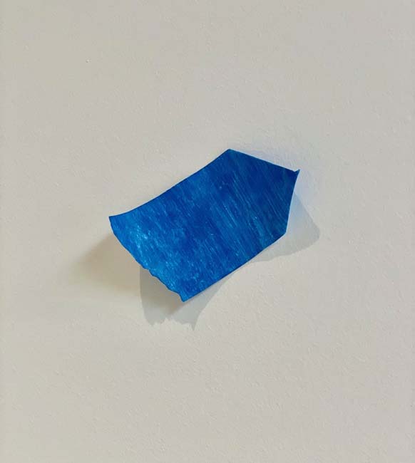 A small strip of blue painters tape crafted of Tyvek and gouache paint, by artist Tamara Johnson.