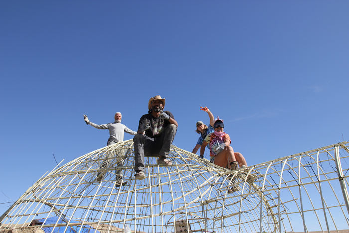 Stephen Clarke and his team pose on top of the hemp dome scaffolding they constructed during Building Man