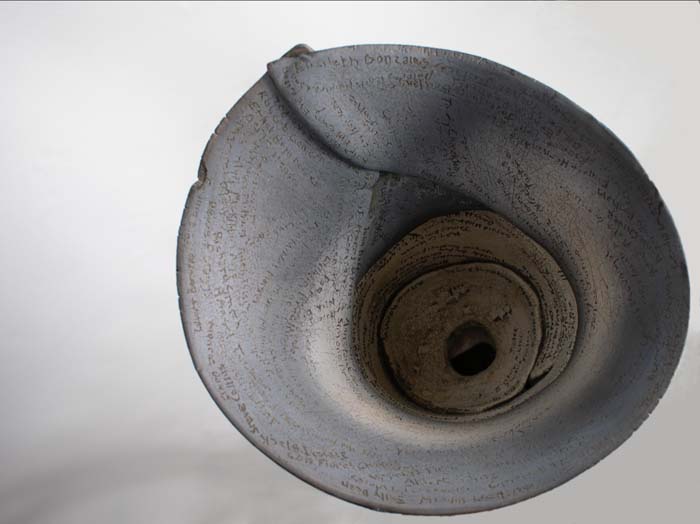 Gray raku fired ceramic cylinder with names inscribed inside.