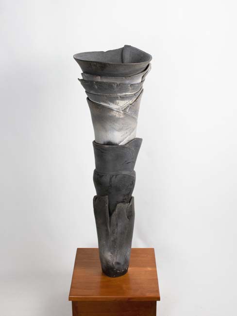 Tall gray and white cylindrical raku fired clay piece.