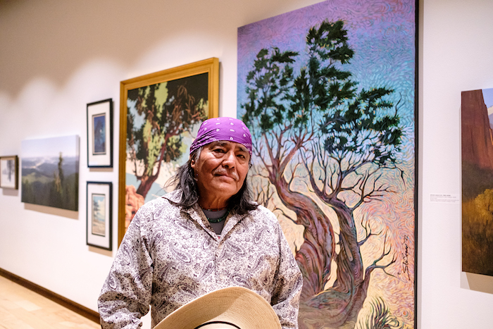 Shoto Begay next to his painting Stands with Light at Souther Utah Museum of Art