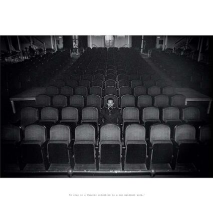 Black and white photograph of a man sitting in the middle of an otherwise empty theater with the words "To stay in a theater attentive to a non existent work" printed below.