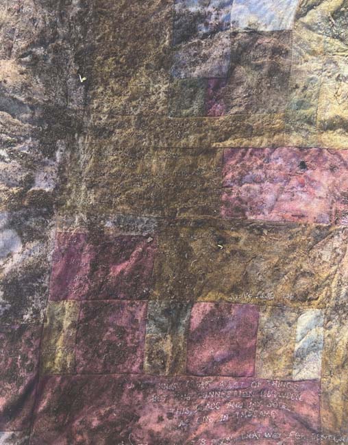 A patchwork quilt with irregular shapes covered with soil.