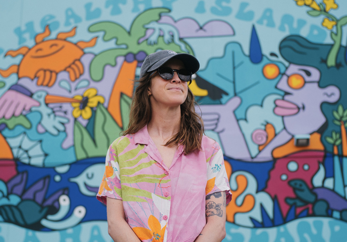 Hannah Eddy stands in front of one her murals
