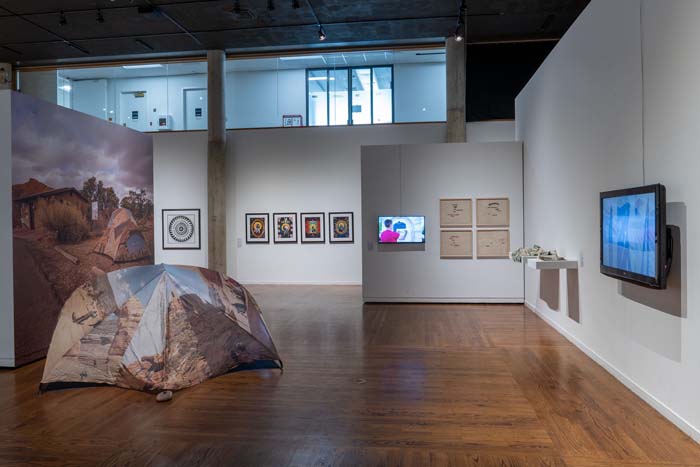Installation view of the San Pete County section of A Greater Utah, with a tent printed with an image of Arches National Park on it.