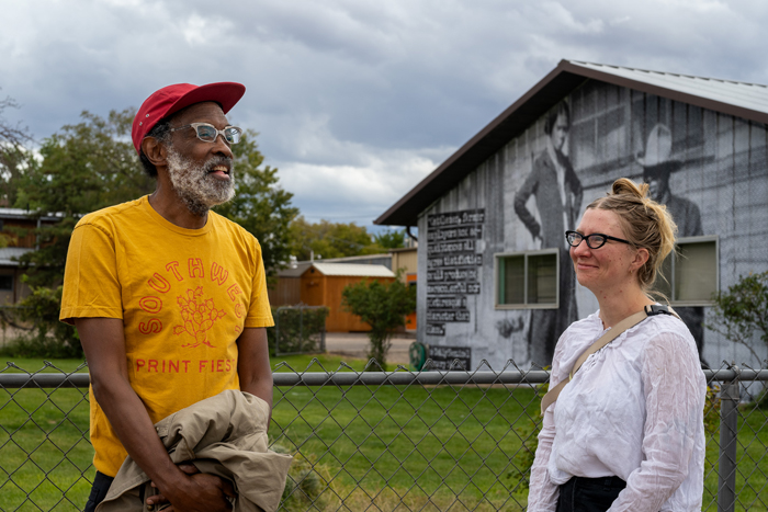 Chip Thomas stands in front of the Charlie Glass mural with Melisa Morgan, the assistant director of Moab Arts