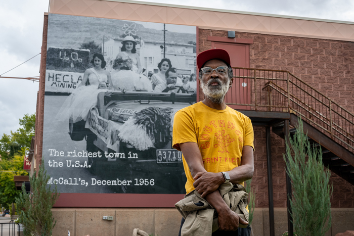 Chip Thomas poses in front of a mural he installed outside of the Moab Museum