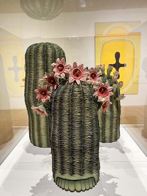 Three ceramic sculptures of blooming cacti, sprouting faces and toes.