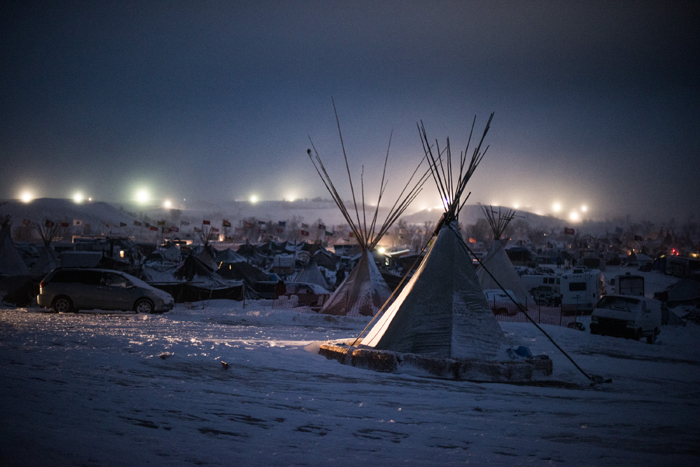 A December 4, 2016, photograph by Russel Albert Daniels shows blizzard conditions and Dakota Access Pipeline security lights 