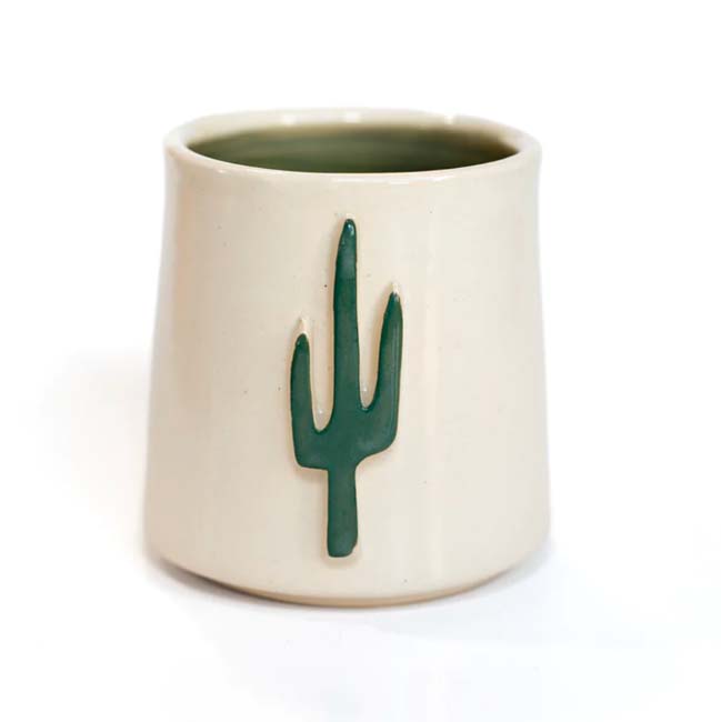 A white handmade ceramic sipping cup with single green saguaro cactus.