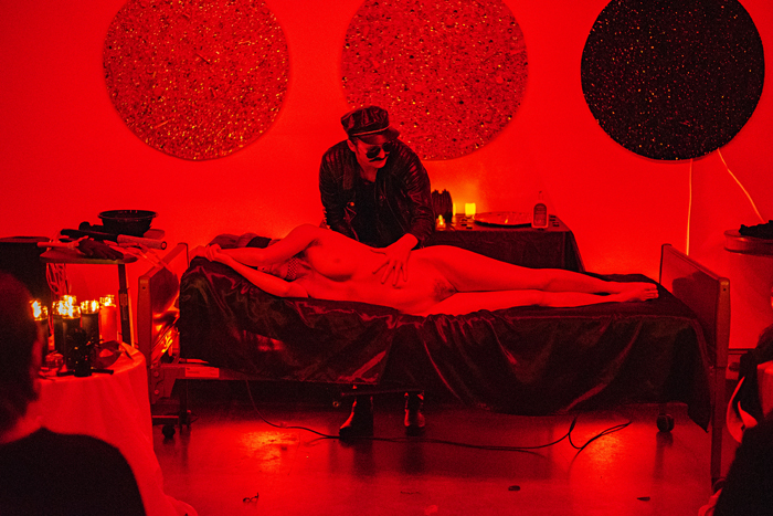 Black Mass Blood Ritual performance still of a naked person laying down on their side