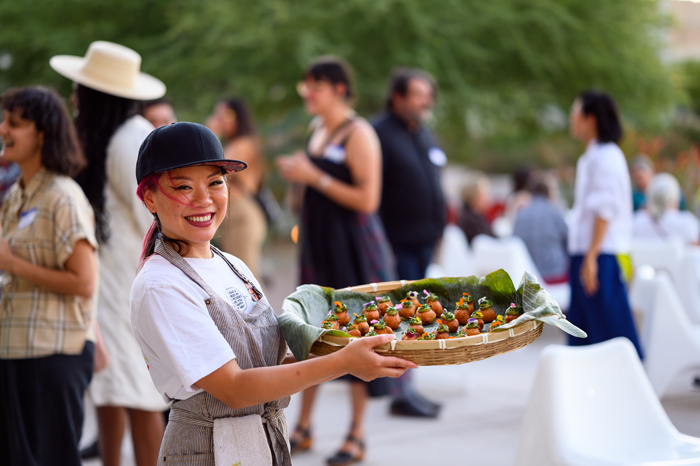 Feng-Feng Yeh, a 2021 awardee for Chinese Chorizo Project, holds food at Night Bloom Social at MOCA Tucson.