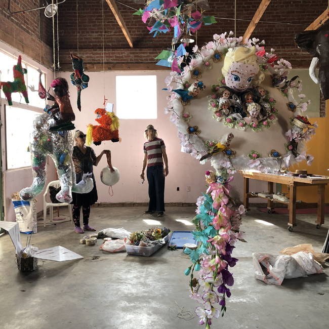 Beatrice Moore and Tony Zahn set up for the 2018 Mutant Piñata Show at Weird Garden