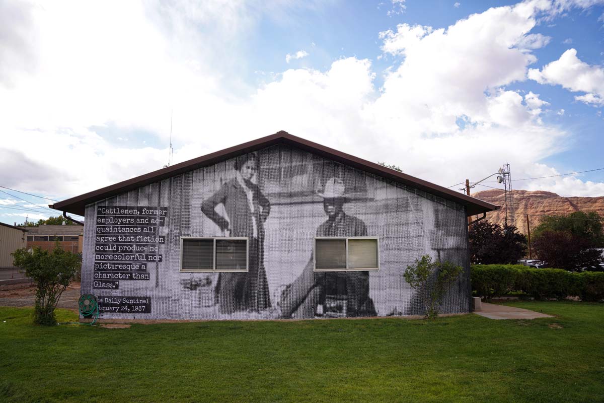 A house with a black and white photo of Black cowboy Charlie Glass with his sister Lucy Pride wheatpasted on the wall.