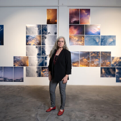 Delilah Montoya standing in front of her photography displayed in the exhibition Divine Immanence at Sanitary Tortilla Factory in Albuquerque. Photo: Brandon Soder.