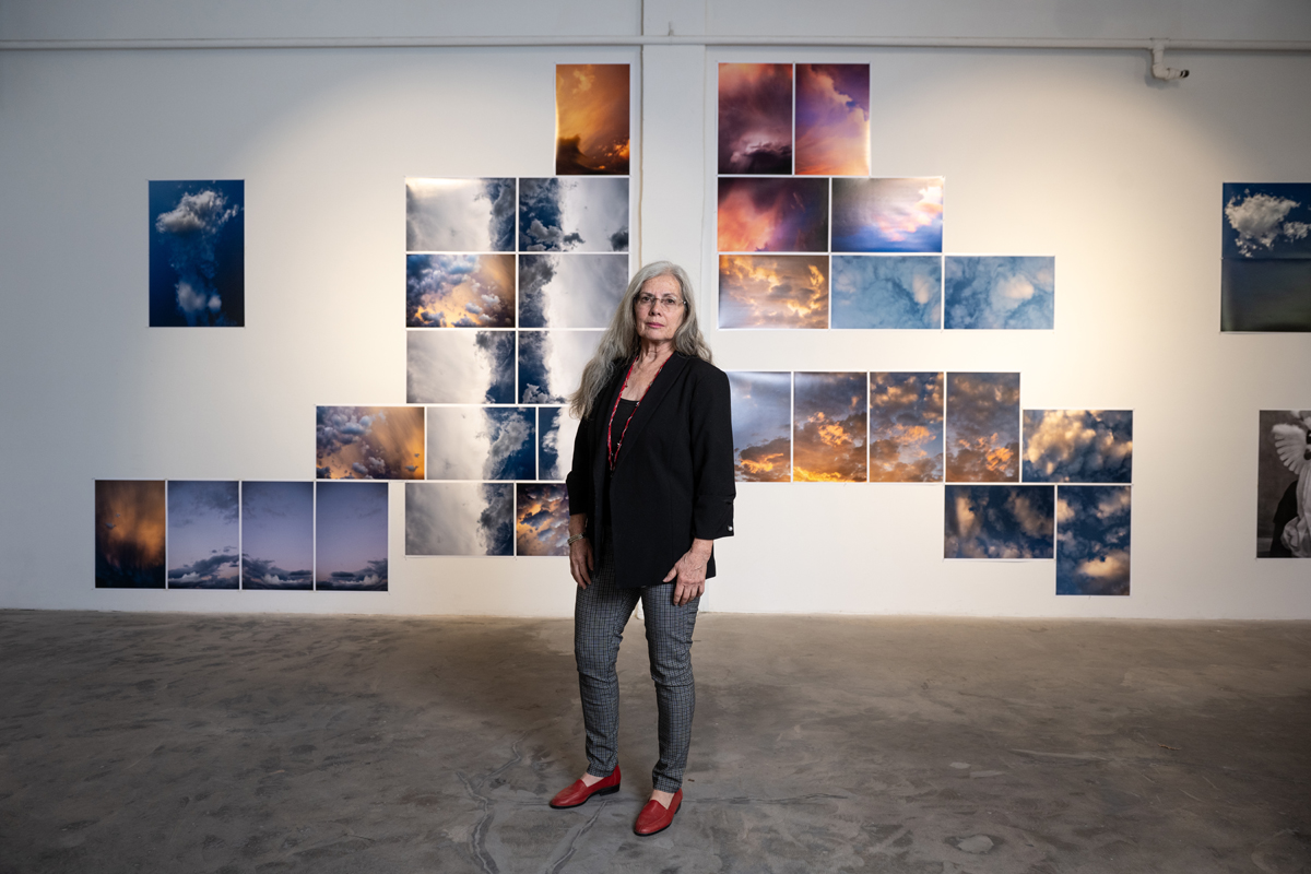 Delilah Montoya standing in front of her photography displayed in the exhibition Divine Immanence at Sanitary Tortilla Factory in Albuquerque.
