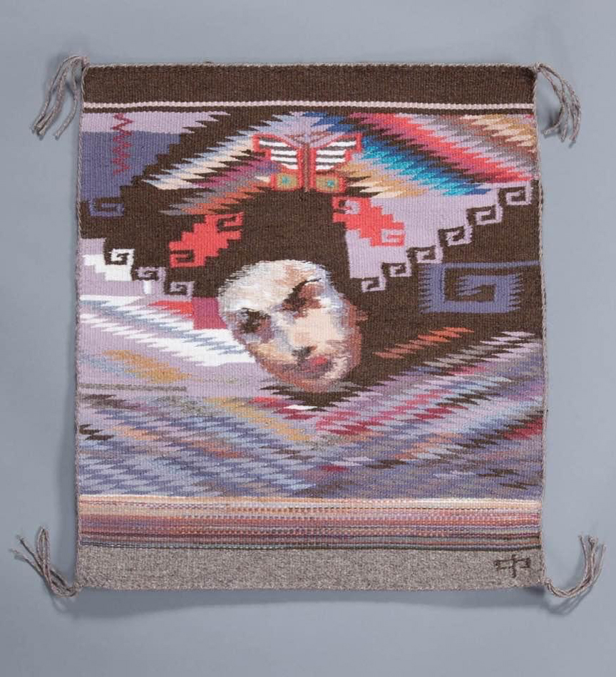 Marlowe Katoney, Scrap Girl, Wool, Heard Museum Collection; Gift of Mark and Julie Dalrymple | Image courtesy of Heard Museum, Craig Smith. Rug dominated by shades of purple and pink, featuring traditional Navajo weaving patterns surrounding a woman’s head.
