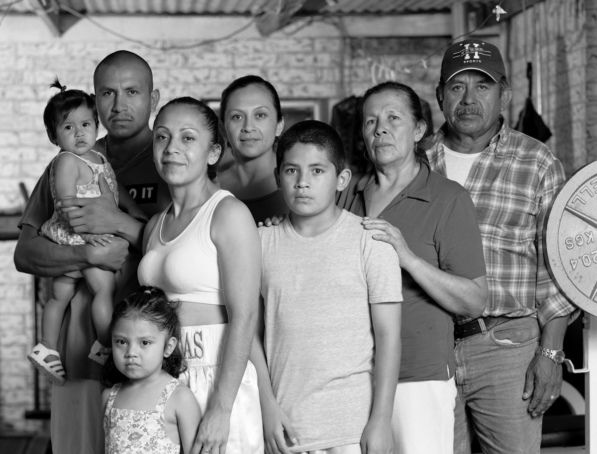 Black and white photograph of a female boxer and her family by Delilah Montoya, Women Boxers: The New Warriors, 2006. 