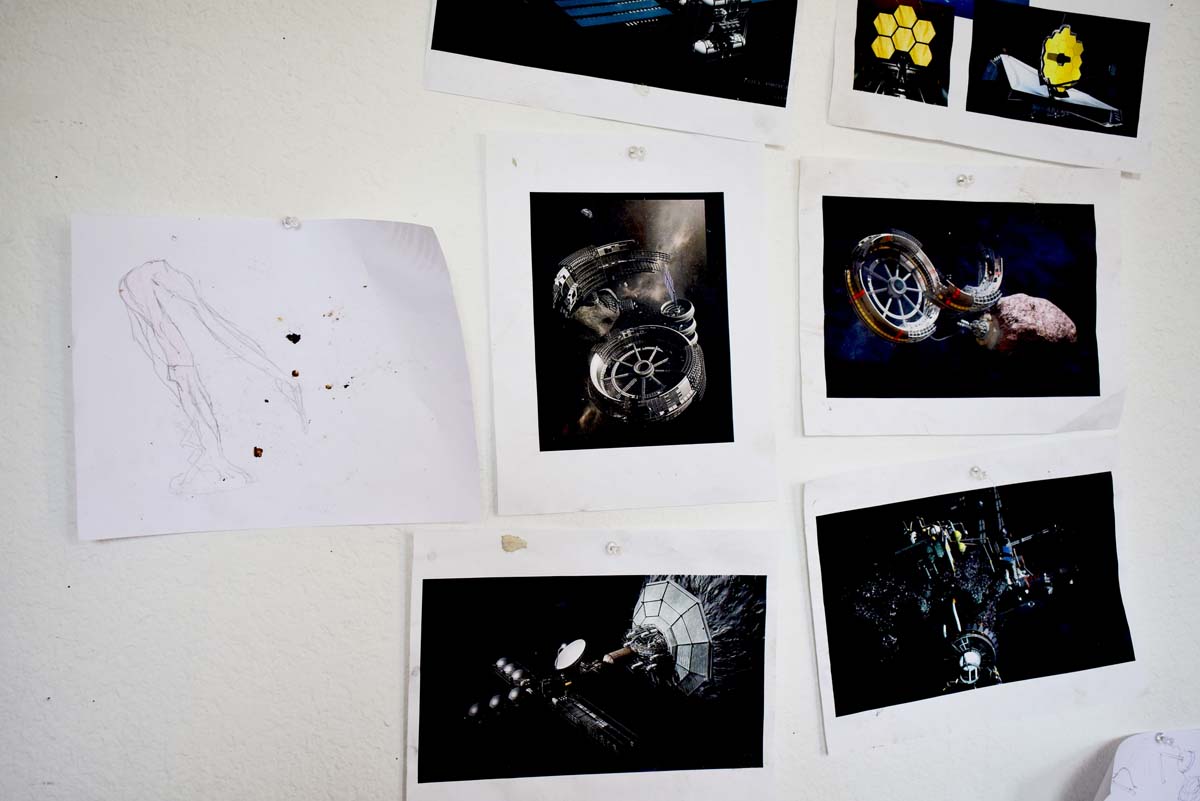 Various photos tacked to a wall related to asteroid mining.