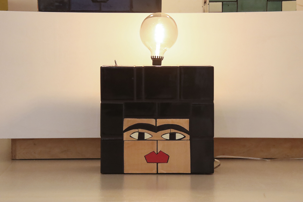 Esther Elia, Tre Pata Ashureta Lamp, 2023, Mexican tile, grout, epoxy, plywood, 14 x 13 x 9.5 in. Cube-shaped lamp made of ceramic tiles with a block-shaped face.