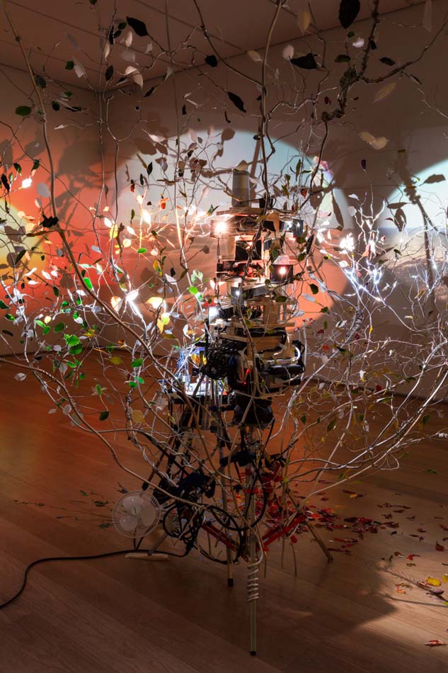 Detail view of Sarah Sze, Love Song, with an aluminum tree and light projections.