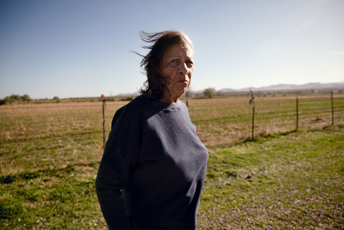 A photo by Sofie Hecht of Louisa Lopez standing on her ranch in San Antonio, New Mexico 
