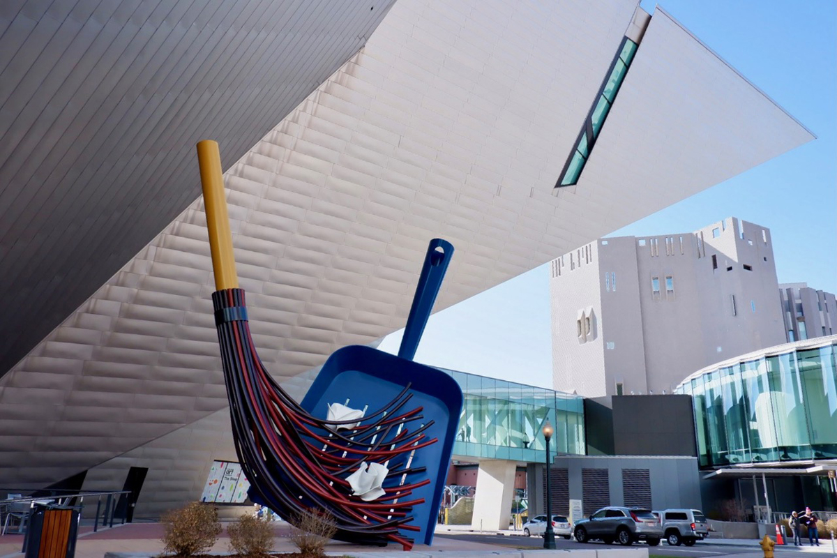 An exterior shot of Denver Art Museum, where a Denver Art Museum union has formed, showing a large sculpture of a broom and dustpan