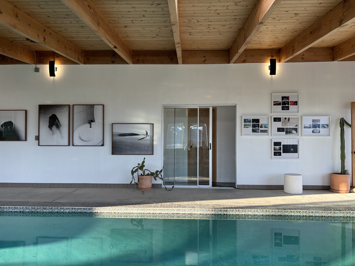 An arrangement of Aapo Huhta’s photographs displayed on a wall overlooking an indoor pool at the High Desert Art Fair