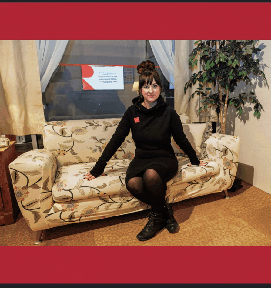 Jenna Maurice sits on a couch at RedLine Contemporary Art Center