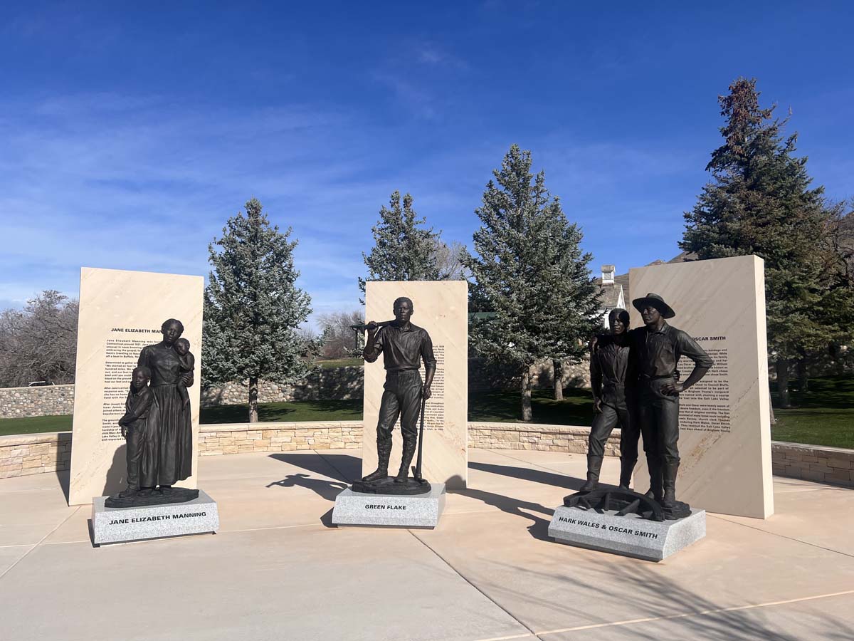 Black Pioneer Monument at This is the Place Heritage Park in Salt Lake City, with three separate bronze statues on low marble pedestals with stone markers behind each one.