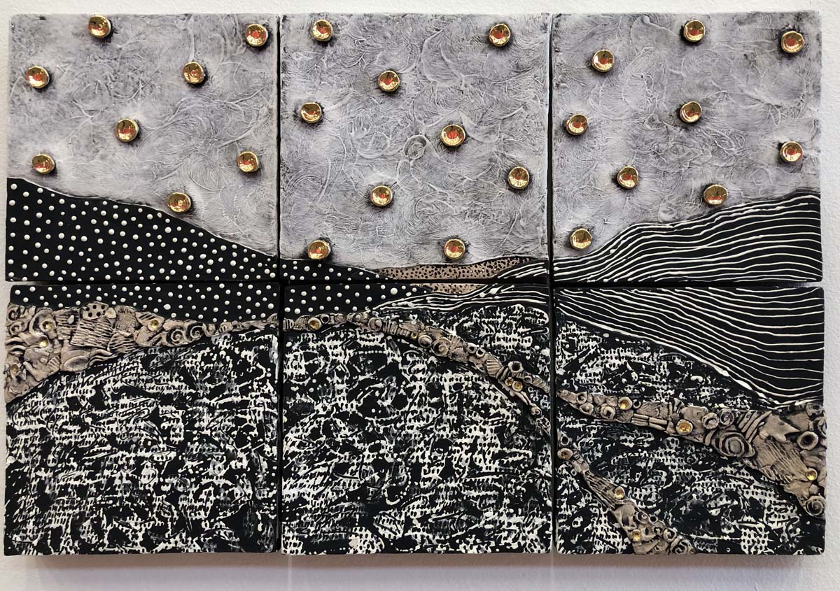 Landscape in six panels in black and white ceramic, with multiple gold discs across the sky.
