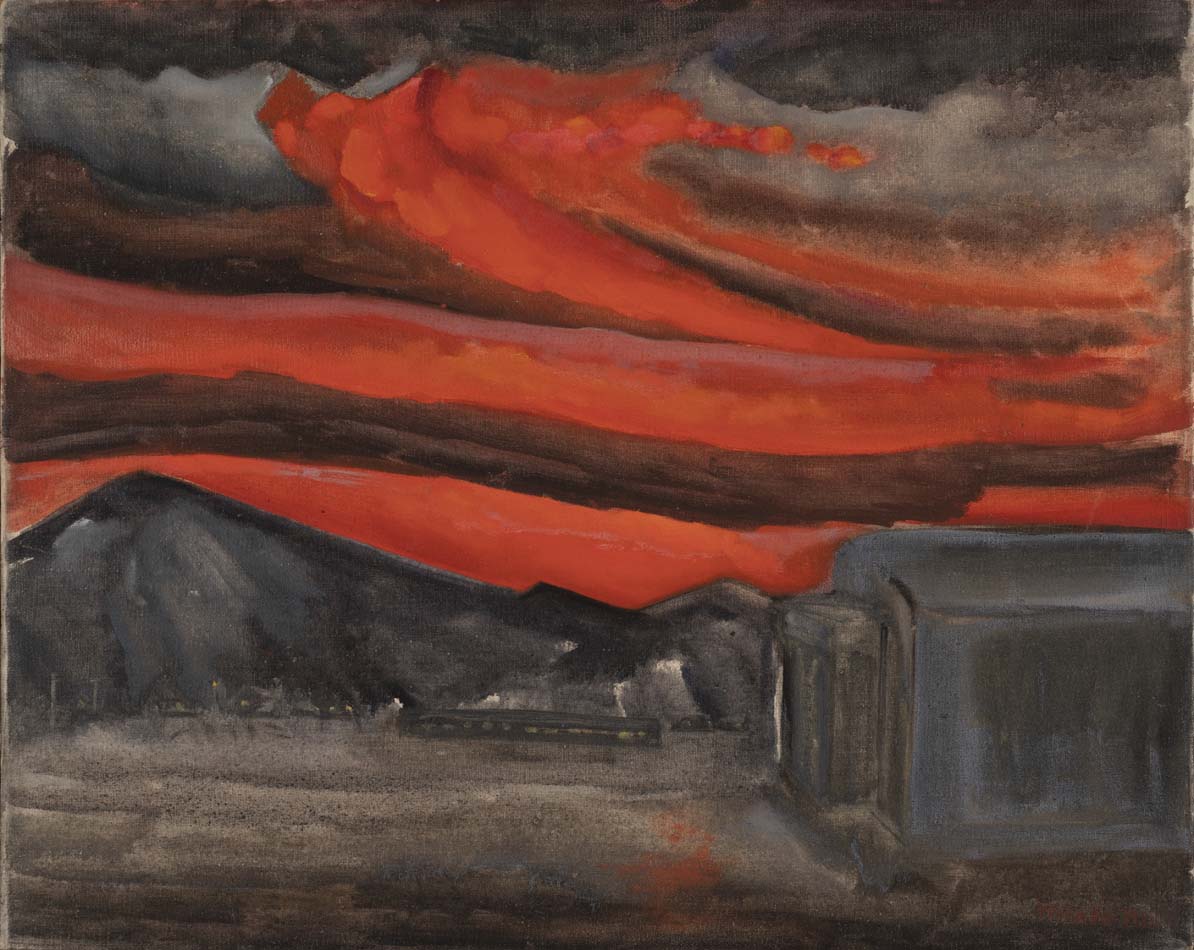 Image of red sky with clouds, mountain peak to left, barracks to the right.