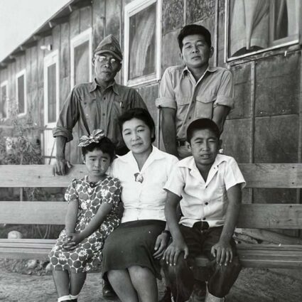 Black and white family photograph of the Hibi family at Topaz internment camp—Hisako (front and center) flanked by daughter Ibuki and son Satoshi; Matsusaburo with glasses in the back, next to Hisako’s brother, Hisao Shimizu, ca. 1945.