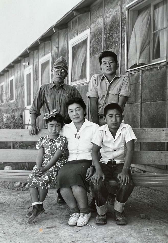 Black and white family photograph of the Hibi family at Topaz internment camp—Hisako (front and center) flanked by daughter Ibuki and son Satoshi; Matsusaburo with glasses in the back, next to Hisako’s brother, Hisao Shimizu, ca. 1945. 