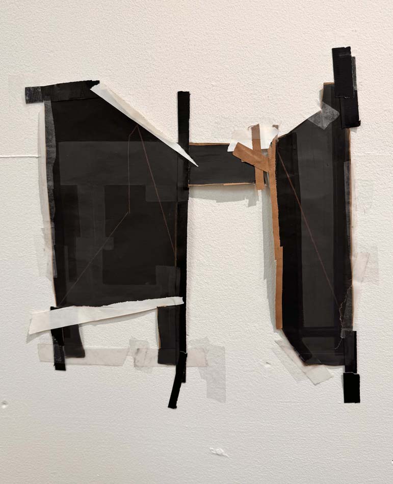 An irregularly shaped collage made of black paper in two sections connected by a bridge, with tape.