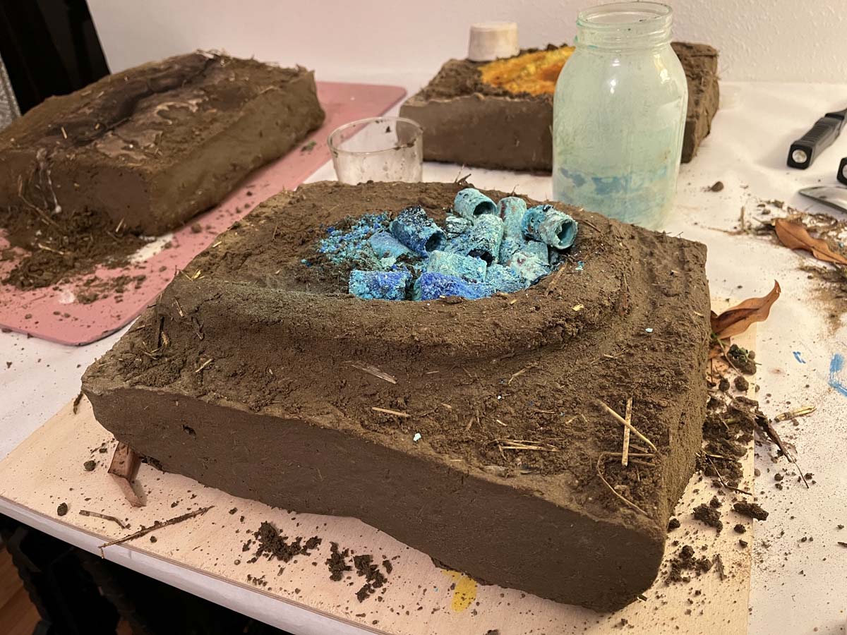 Adobe brick with turquoise elements nested within it. 