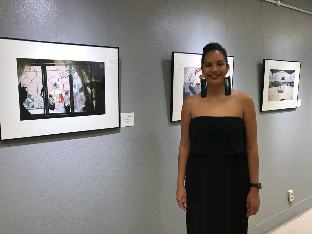 Maria Nancy Thomas with her photographs at the Phoenix Center for the Arts
