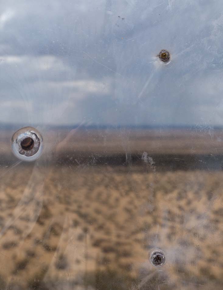 Two bullet holes on glass.