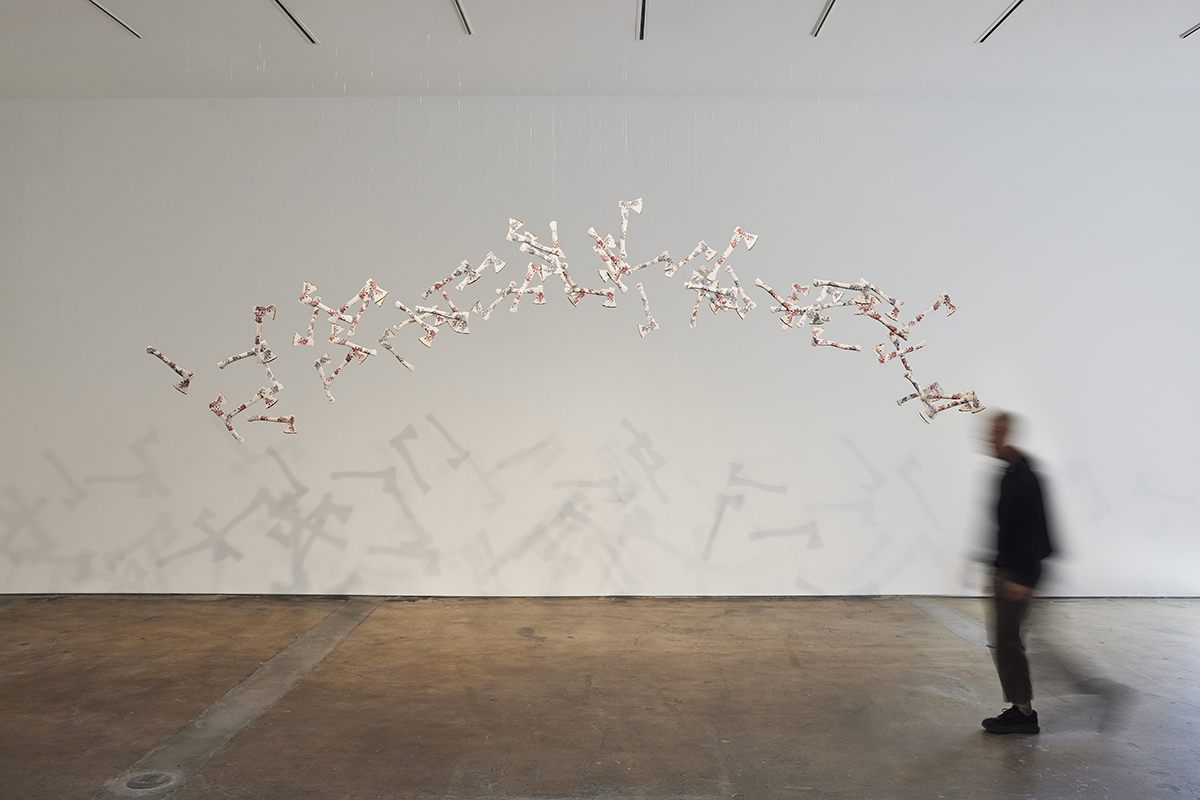 Art installation featuring suspended red and white tomahawks made from porcelain.