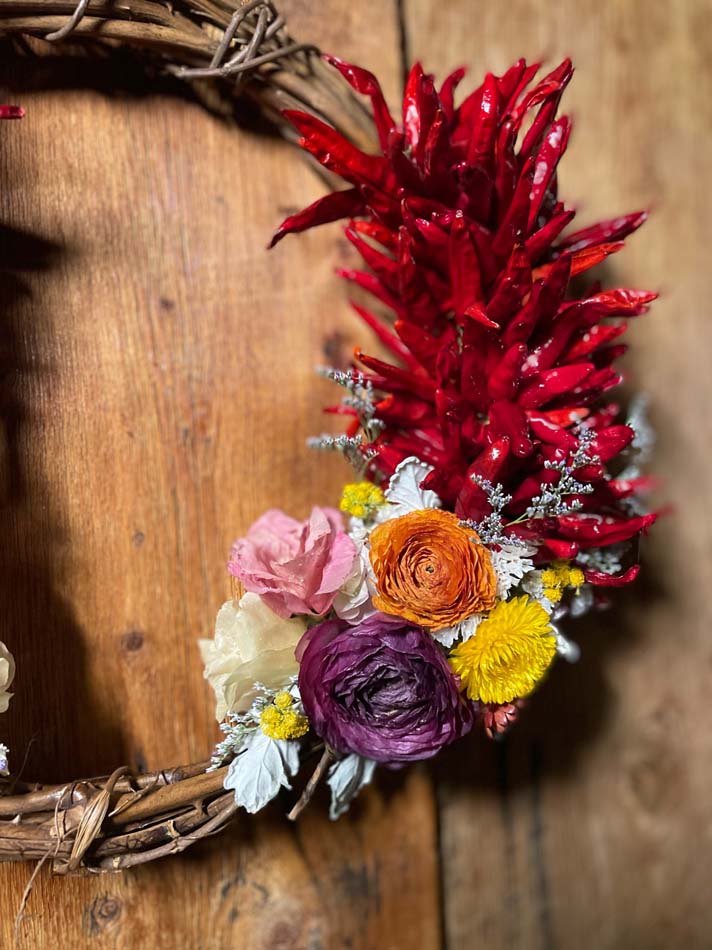 Wreath with red chiles and dried flowers.