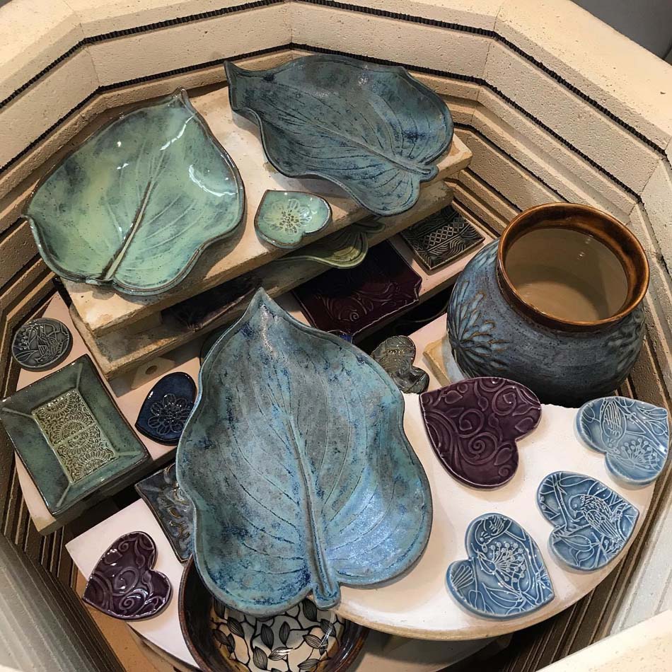 Variety of blue and green ceramic works by Sandia Heights artist Laura McIndoo. 